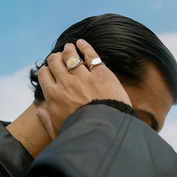 Model with hand on his hair wearing 2 rings, Compass Ring & Silver Signet Ring