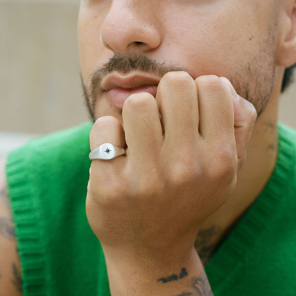 Model wearing a green knitwear, wearing the Silver Envy Signet Ring on his pinky finger - Serge DeNimes