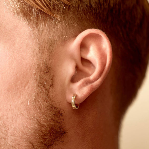 Model wears gold hoop earring in his ear lobe - Serge DeNimes
