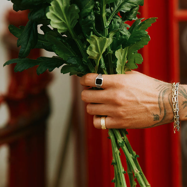 Model holding a bunch of flowers wearing 2 Sterling silver rings and 2 bracelets
