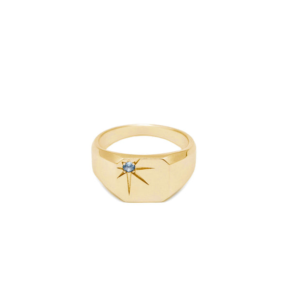 Gold plated silver ring with a blue gemstone in an oversized star setting on a white background