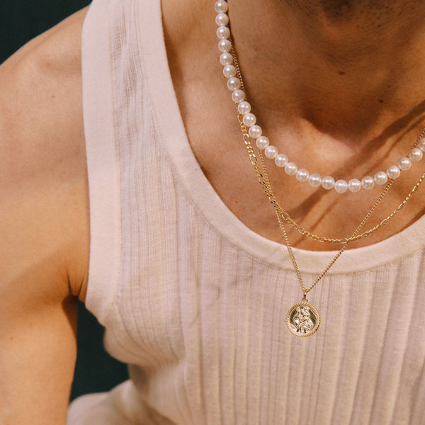 Model wears white ribbed vest with 3 necklaces layered - Serge DeNimes