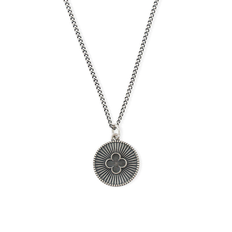 Silver necklace with round pendant with dotted border, striped star burst background and 4 leaf clover motif - Serge DeNimes