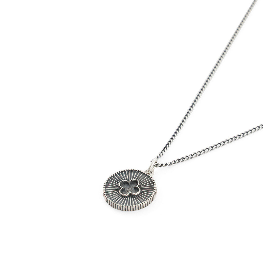 Silver necklace with round pendant with dotted border, striped star burst background and 4 leaf clover motif - Serge DeNimes