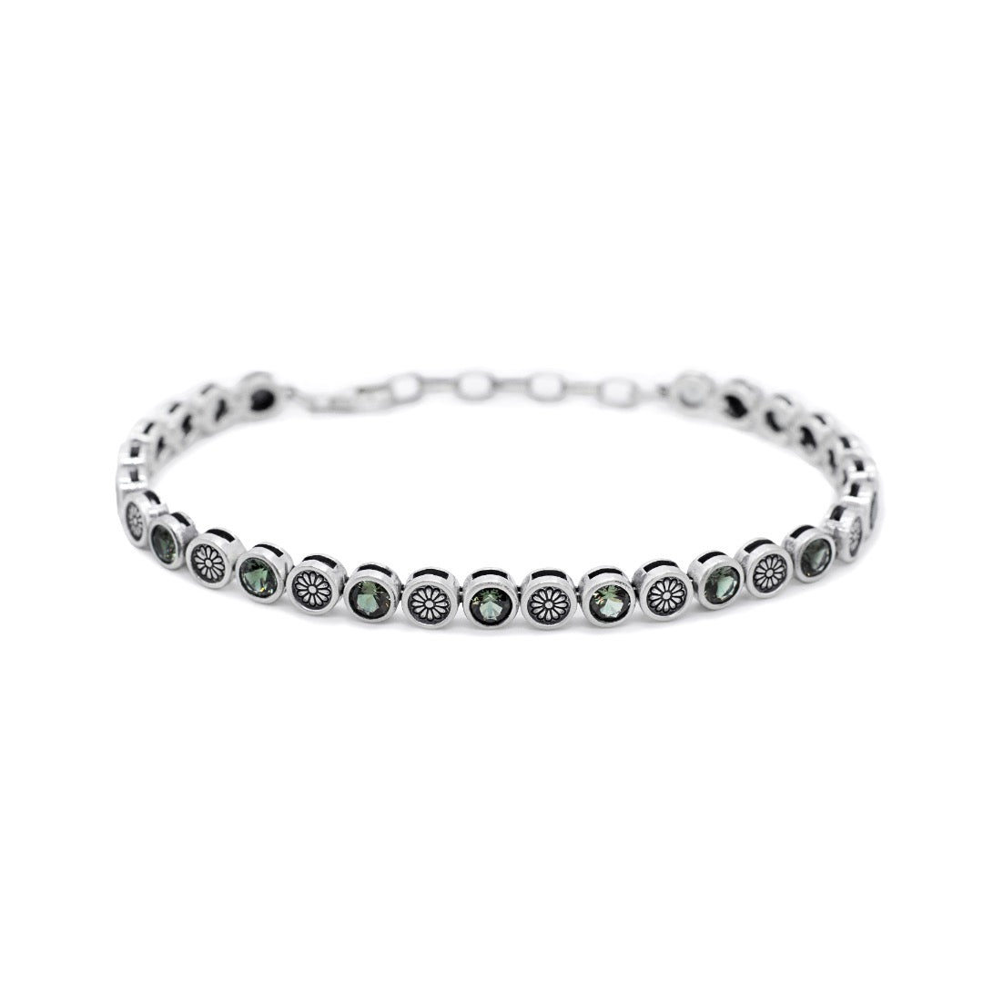 Silver bracelet with green gemstones on a white background