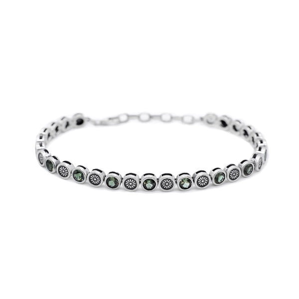 Silver bracelet with green gemstones on a white background