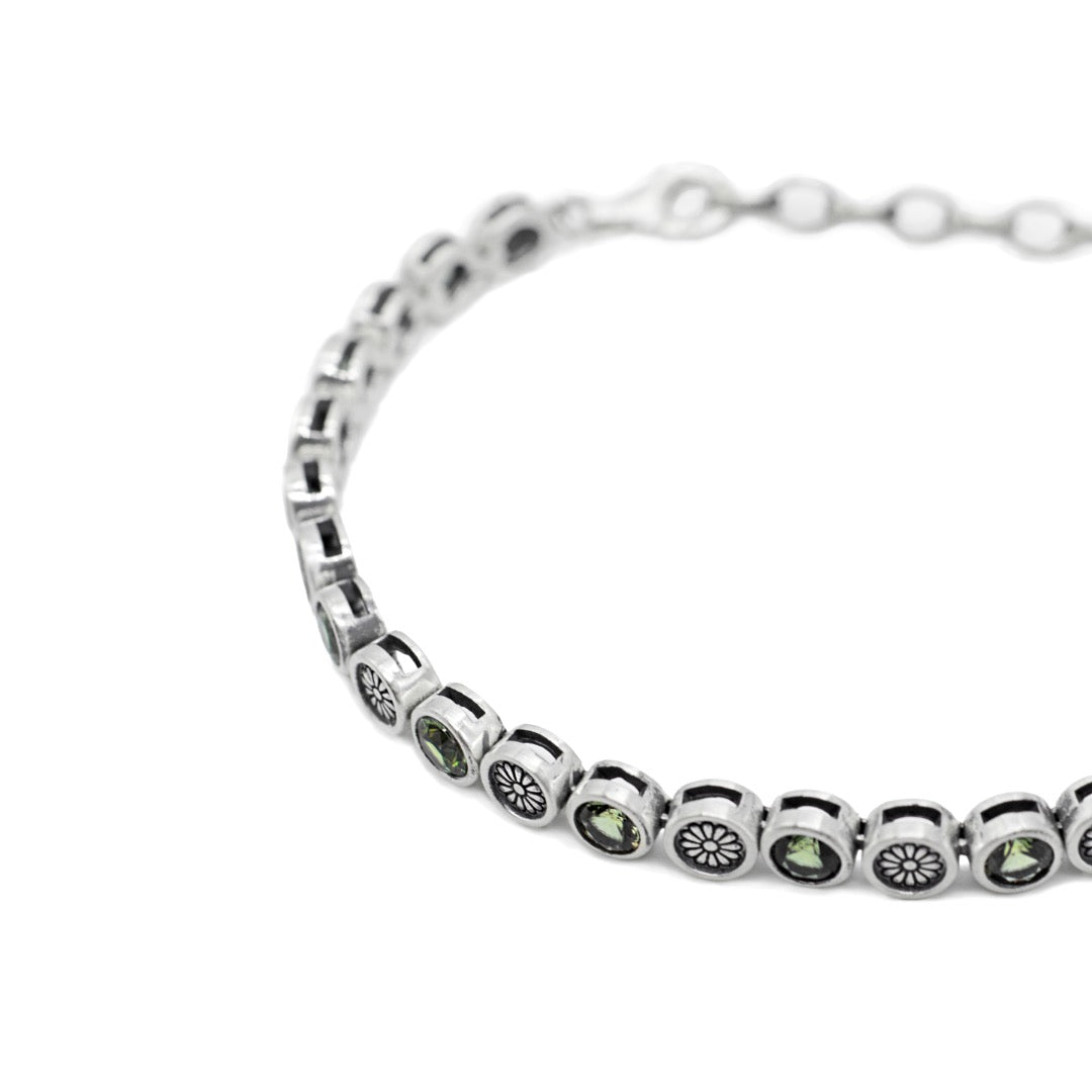 Close up of Silver bracelet with green gemstones on a white background