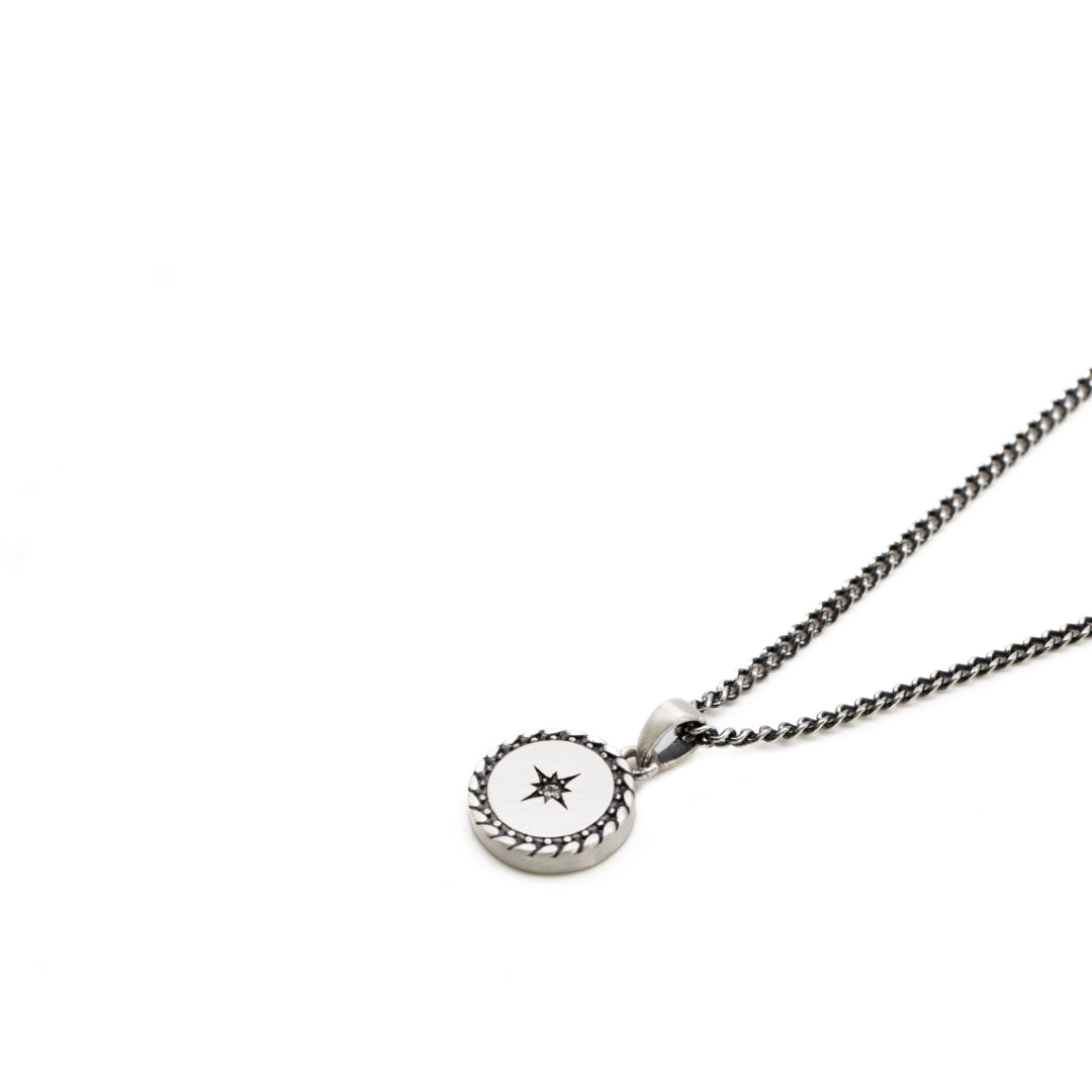 Silver necklace with slim curb chain and round pendant with diagonal border, star setting and clear gemstone - Serge DeNimes