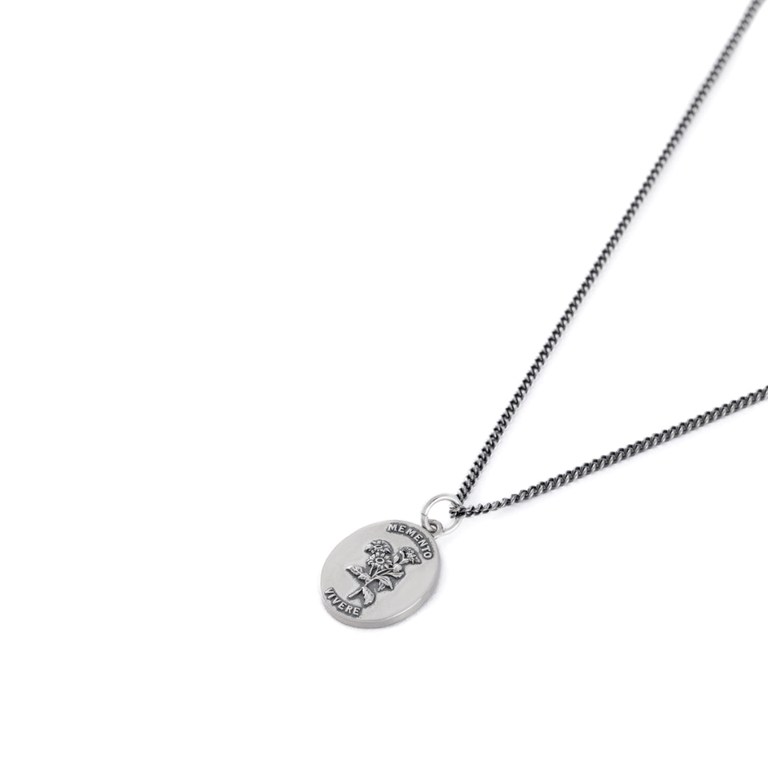 Silver pendant necklace with flower depiction on white background