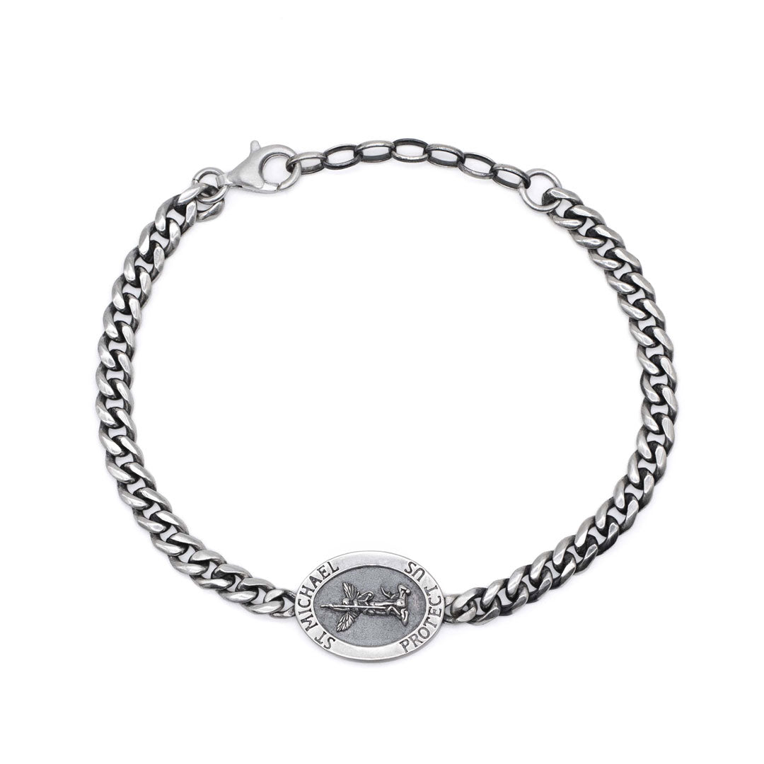 Birds eye view of a Silver chain bracelet with an oval pendant depicting St Michael by Serge DeNimes