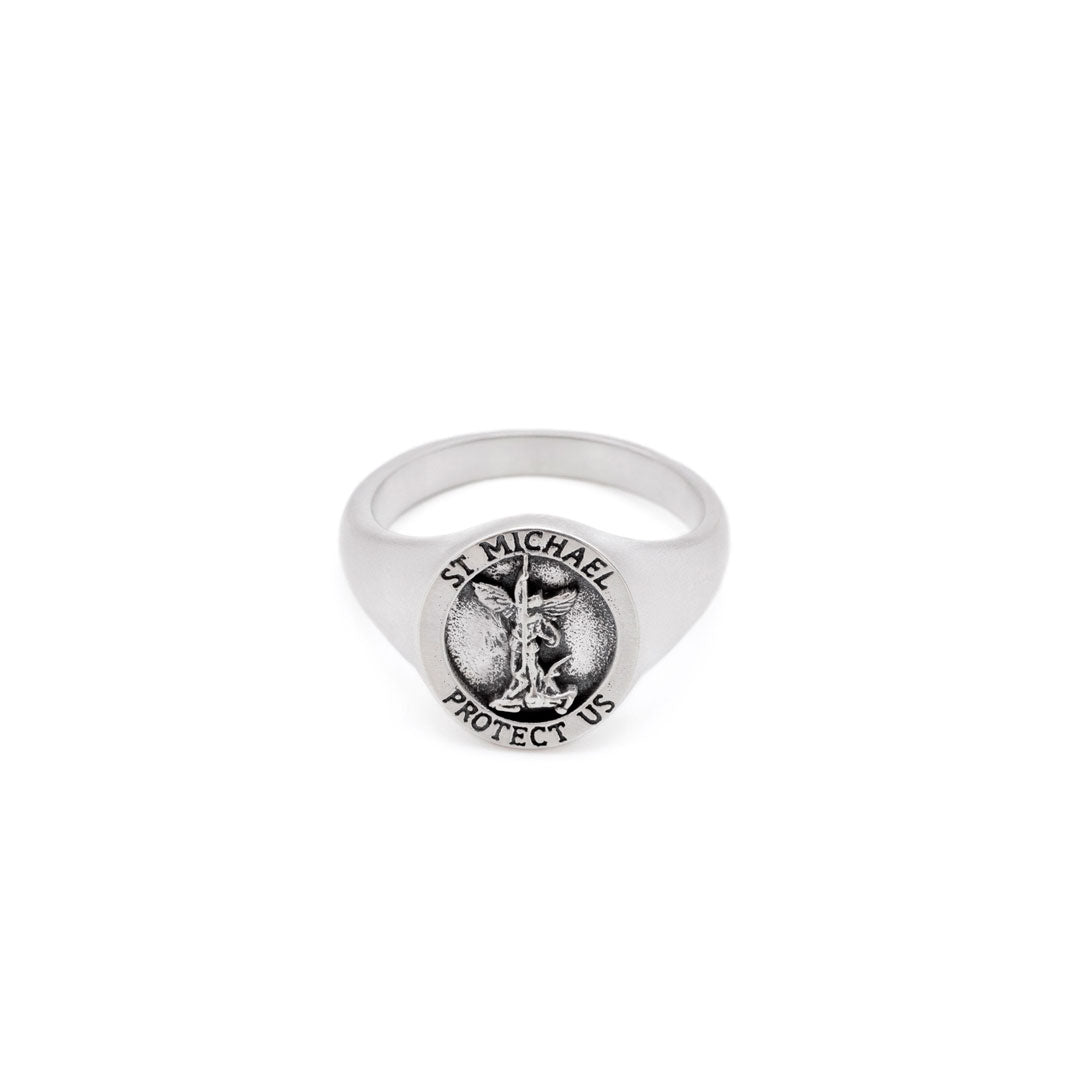 Silver ring with a depiction of St Michael on the face sitting on a white background by Serge DeNimes
