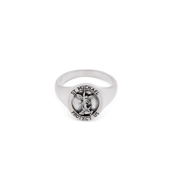 Silver ring with a depiction of St Michael on the face sitting on a white background by Serge DeNimes