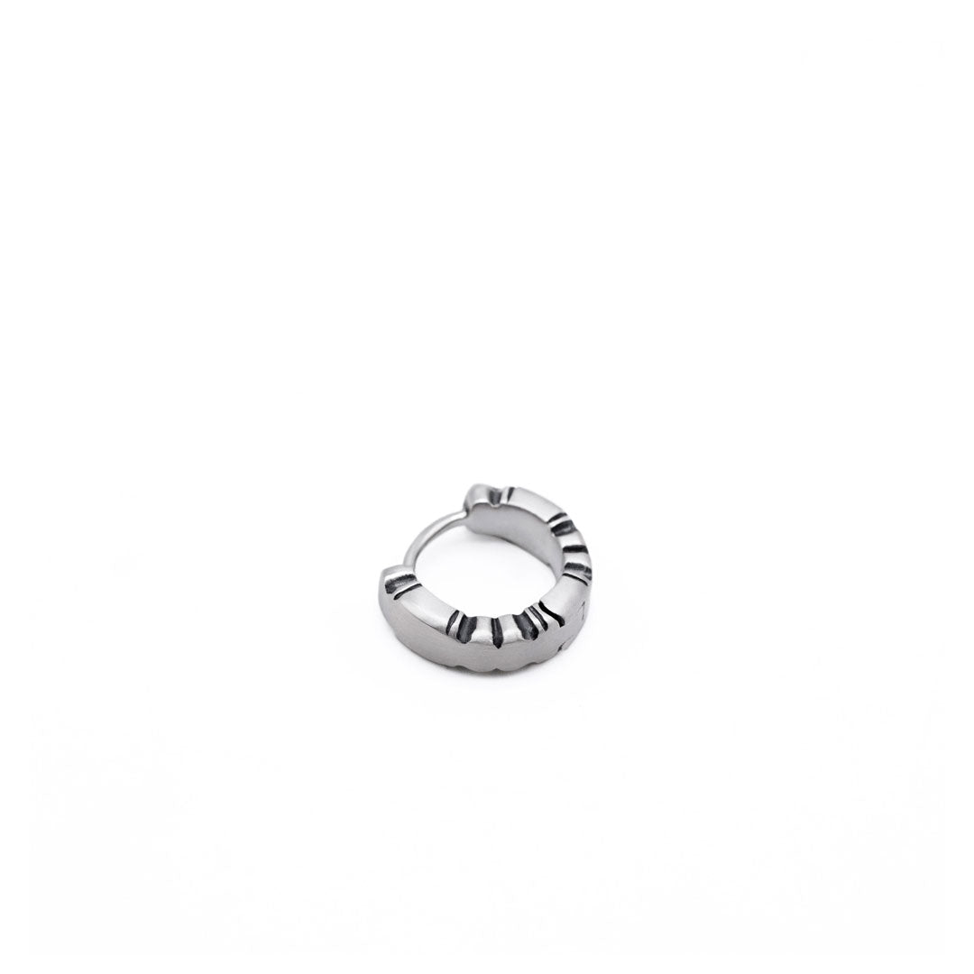 Silver Huggie Earring with shapely edges by Serge DeNimes in a closed pose