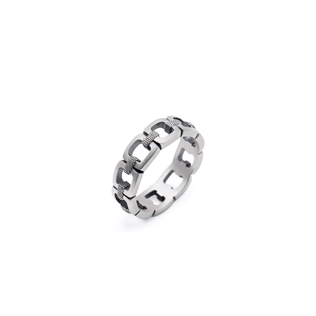 Silver chain-link ring on a white background by Serge DeNimes
