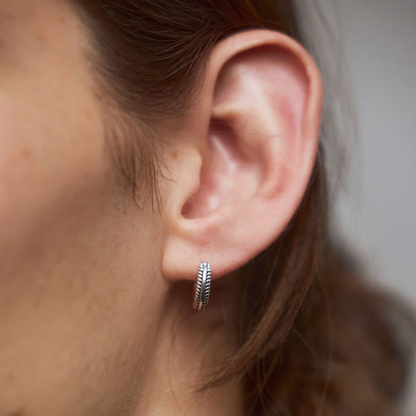 Model wearing silver hoop earring in ear lobe