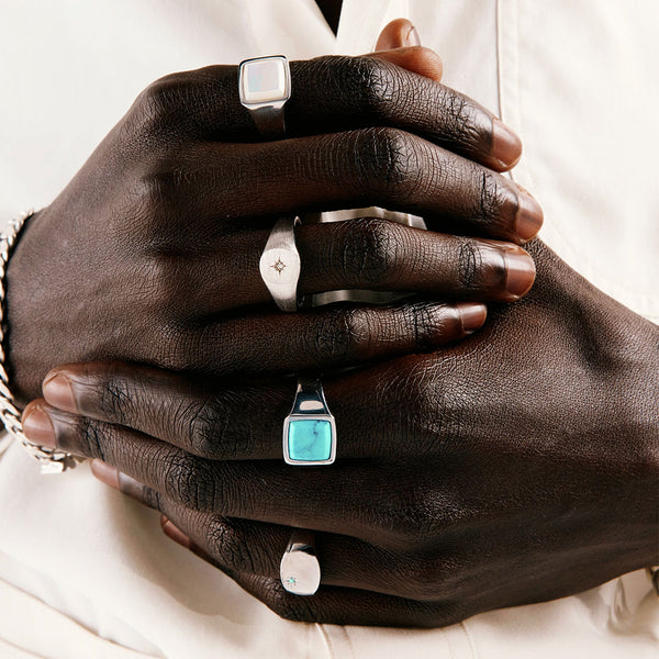 Close up of a persons hands wearing multiple silver rings