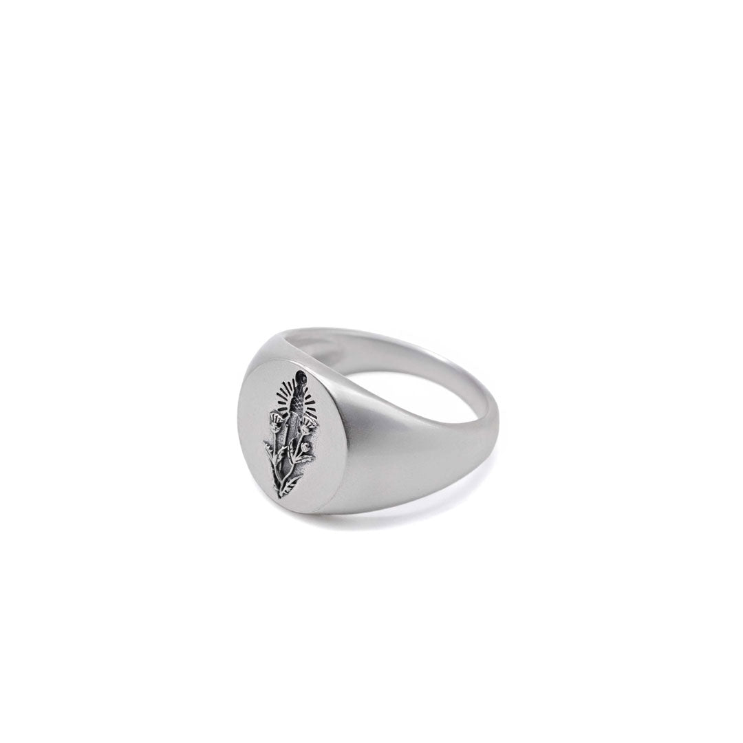 Silver oval ring with a thistle and sword design on a white background