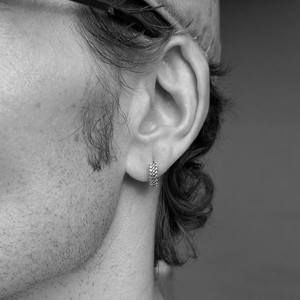 Male model wearing Silver earring in ear lobe