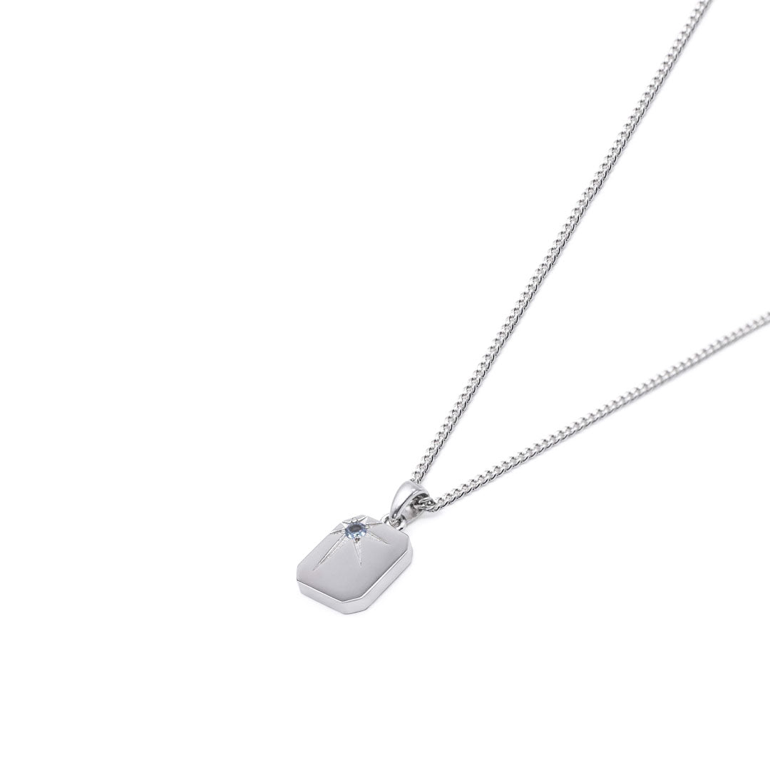 Silver necklace with a rectangular pendant, oversized star setting and pale blue gemstone