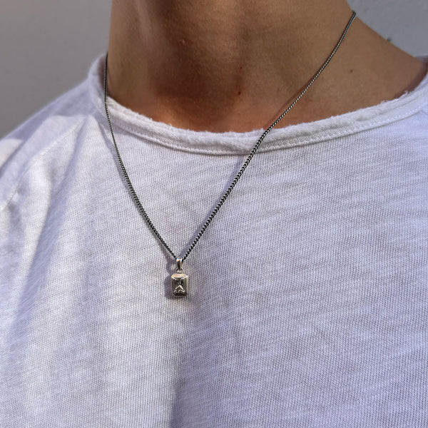 Model wears a white t-shirt under a Silver necklace with large clear gemstone - Serge DeNimes