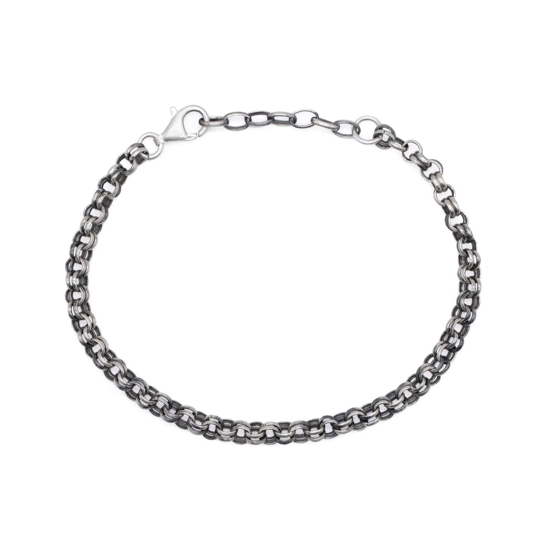 Birds eye view of a Silver chain bracelet on a white background by Serge DeNimes
