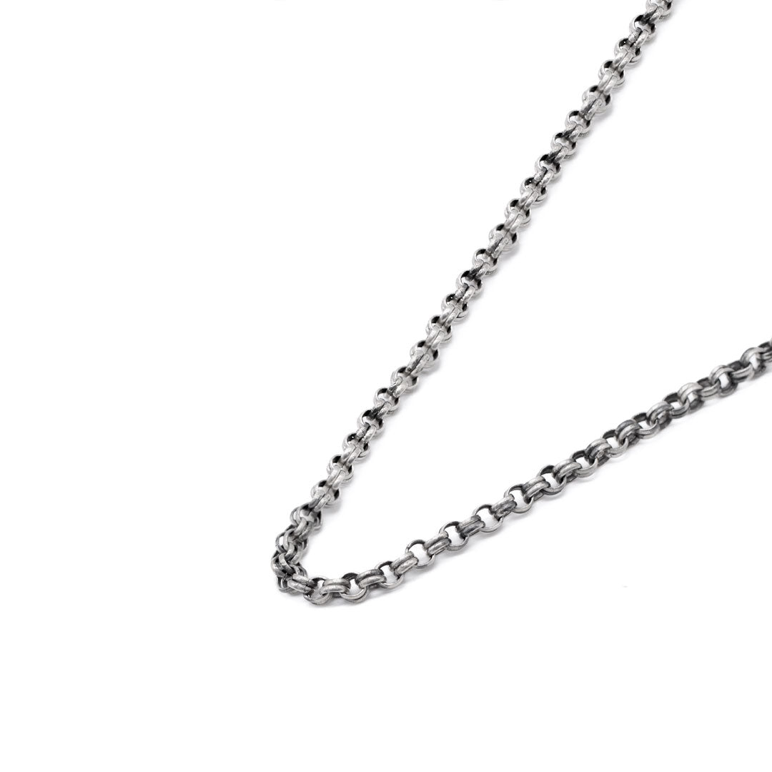 Silver neck chain on a white background by Serge DeNimes