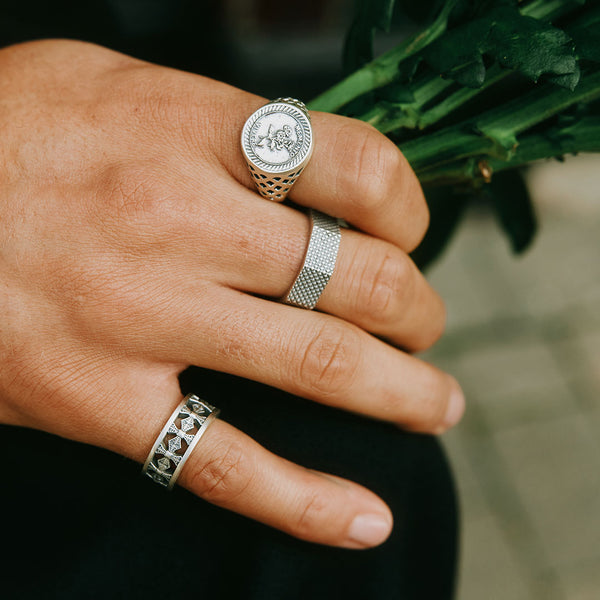 Model hand holding greenery wearing 3 Silver rings