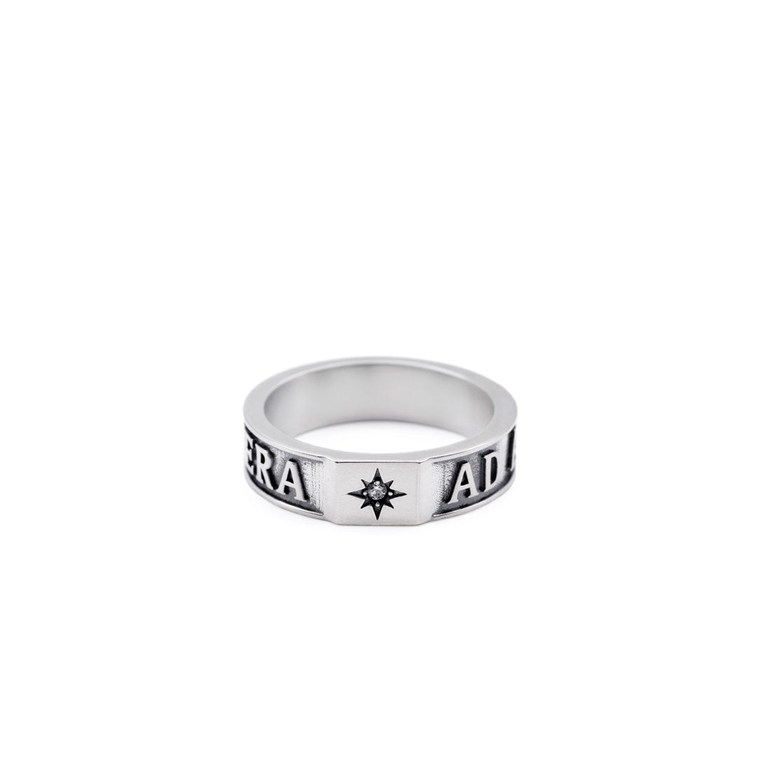 Silver ring with engraved text and a clear gemstone on a white background