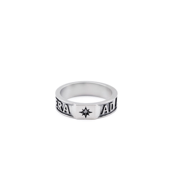 Silver ring with engraved text and a clear gemstone on a white background