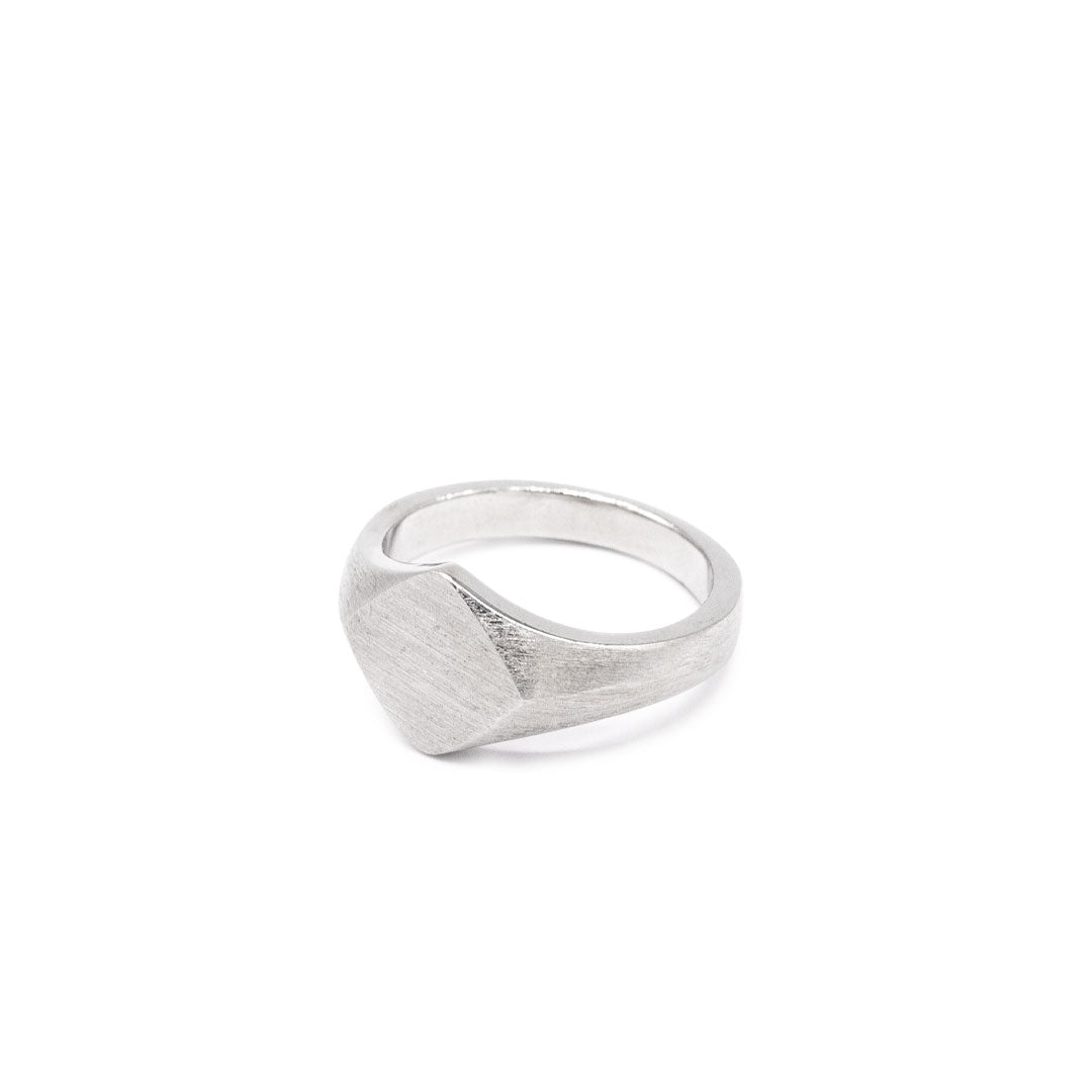 Silver ring with Rhombus shaped face and heavily brushed finish on a white background