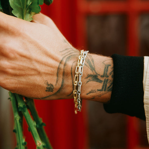 Model arm wearing Gold bracelet and Silver bracelet