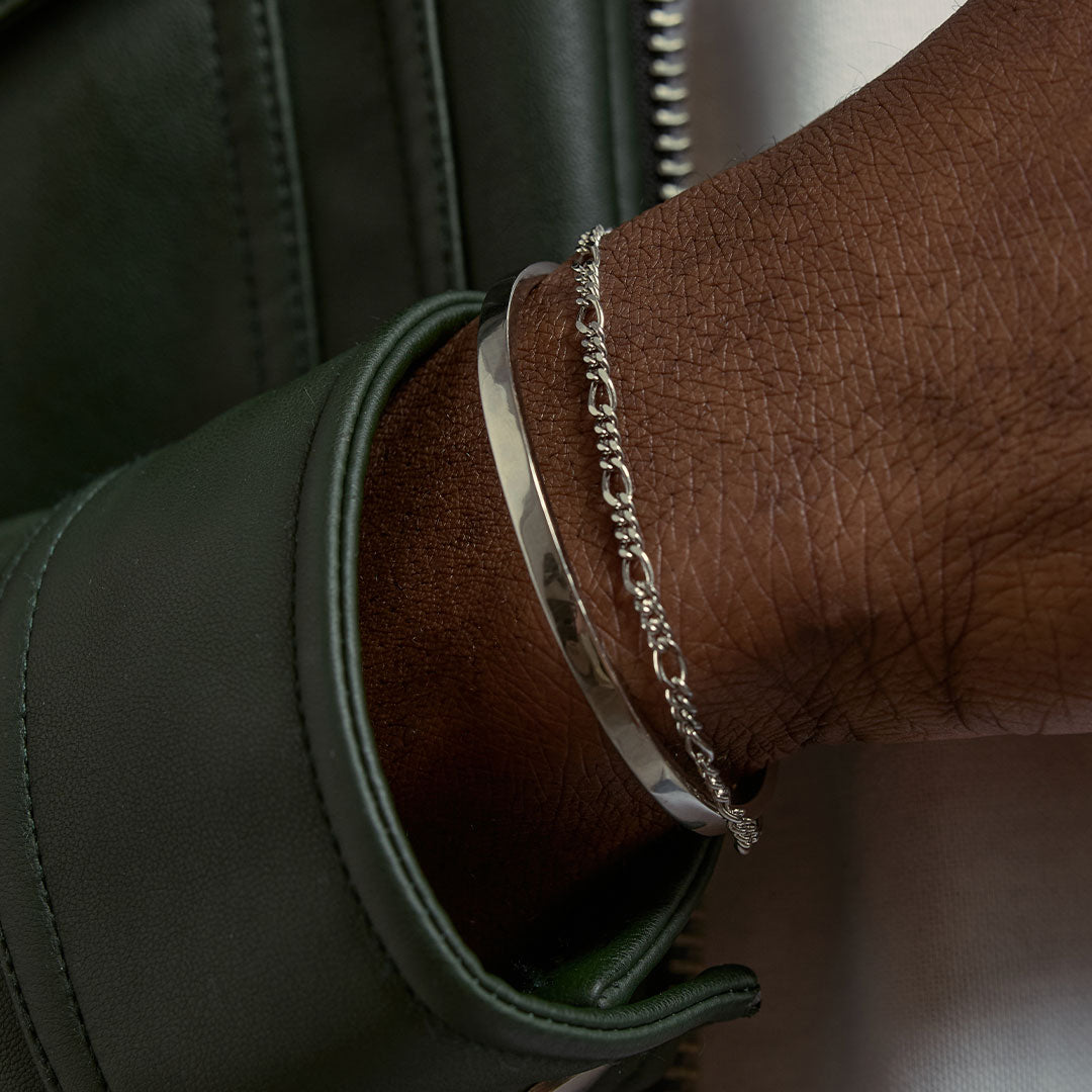 Model wears a dark green leather jacket with a plain Silver Cuff and a Silver Figaro bracelet - Serge DeNimes