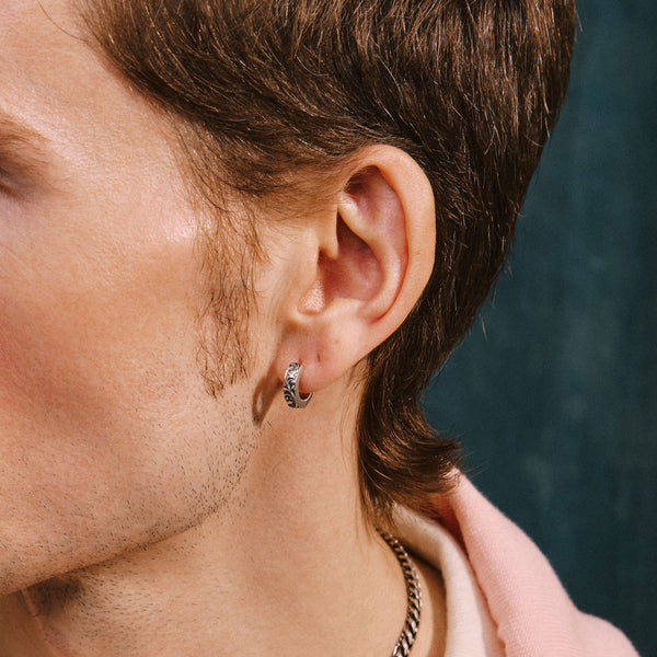 Male model wearing floral motif earring in ear lobe
