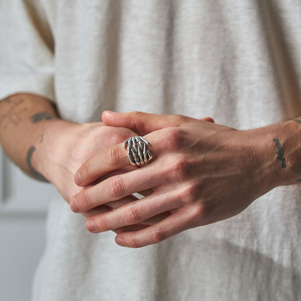 Model holding his hands wearing the Skeleton Hands Ring - Serge DeNimes